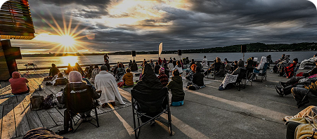 Image de participants faisant face à un beau soleil, tous assis sur un toit ouvert sur l'horizon